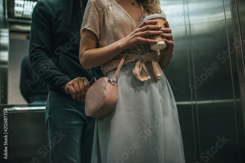 cropped view of robbery pickpocketing smartphone from womans bag in elevator photo