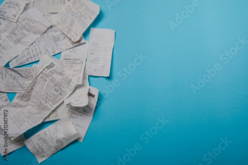 Pile of shopping receipts on blue background photo