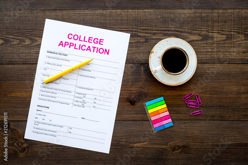 Apply college. Empty college application form near coffee cup and stationery on dark wooden background top view copy space