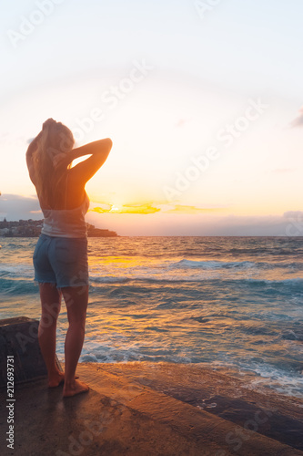 Blonde surfer girl relaxing by the beach