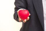 Red heart on business man 's hand.