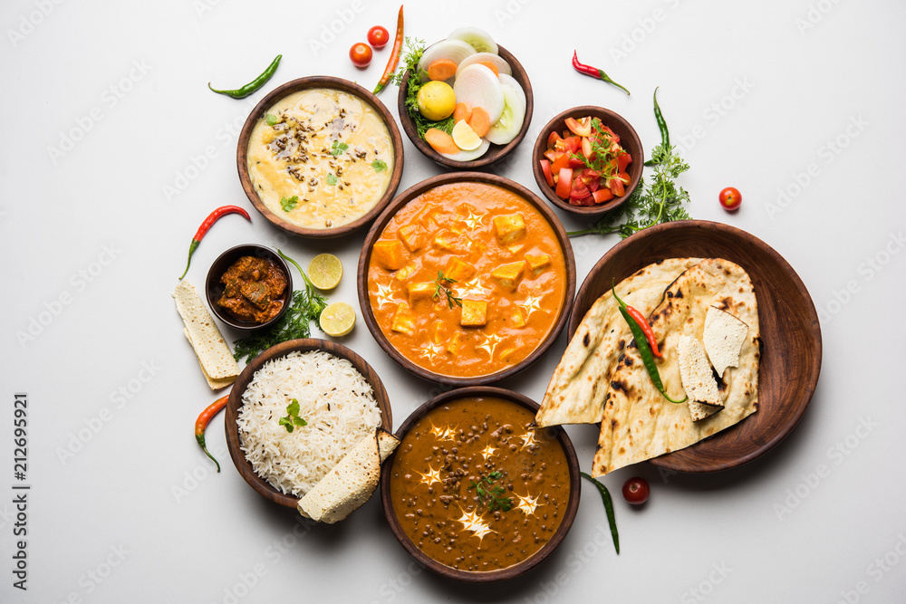 Assorted indian food for lunch or dinner, rice, lentils, paneer, dal makhani, naan, chutney, spices over moody background. selective focus
 - obrazy, fototapety, plakaty 