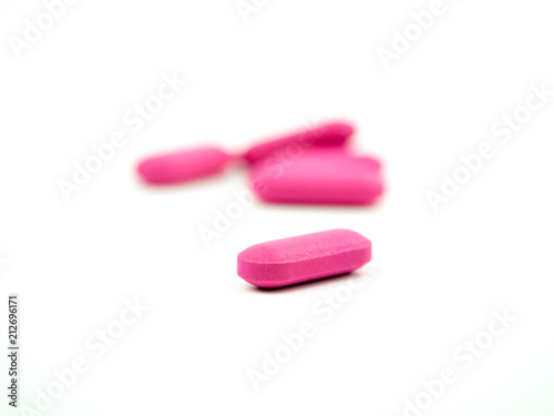 The pink pill is placed on a white background.