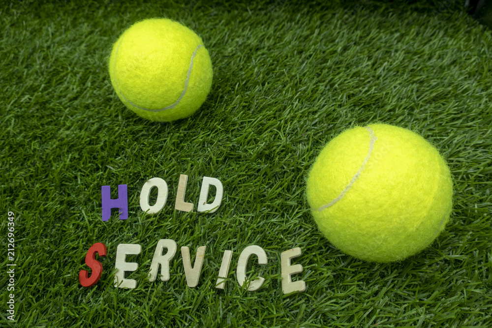 Tennis ball with tennis wording term on green grass