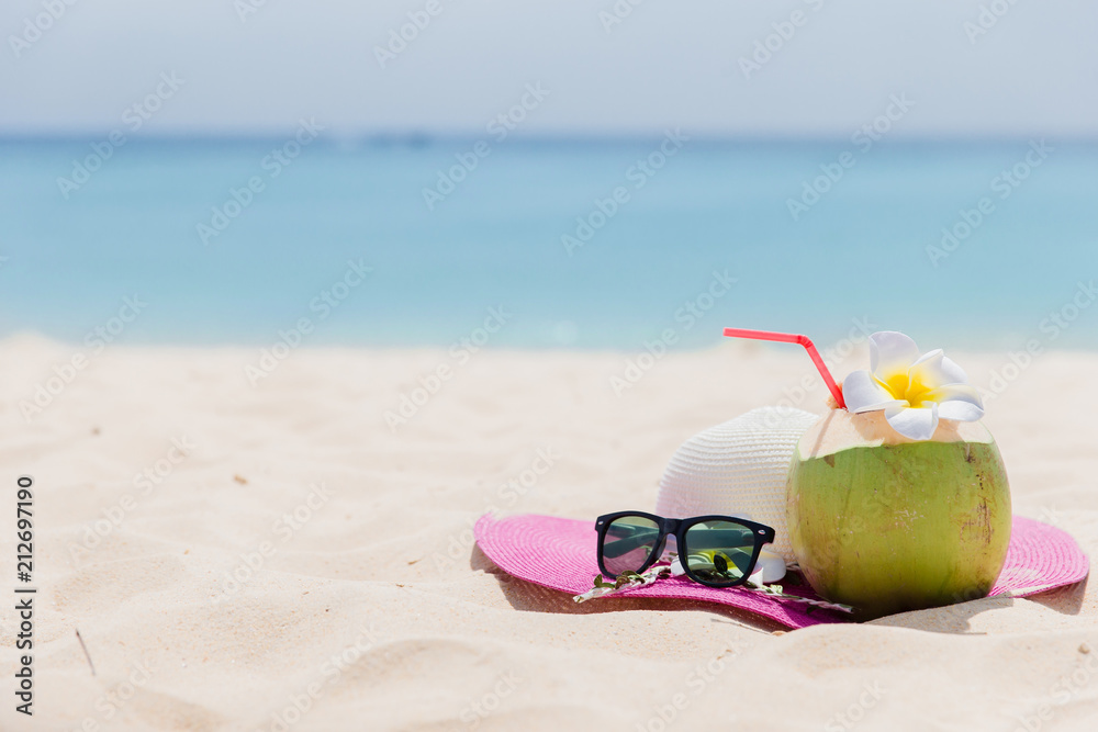 Fresh young coconut lying on the sand beach background with straw ready for drink. Tropical vacation travel concept Fresh young coconut lying on the sand beach background with straw ready for drink. Tropical vacation travel concept
