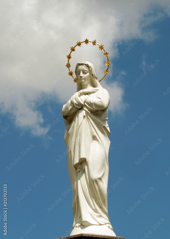 Statue of Virgin Mary as a symbol of love and kindness near catholic church.