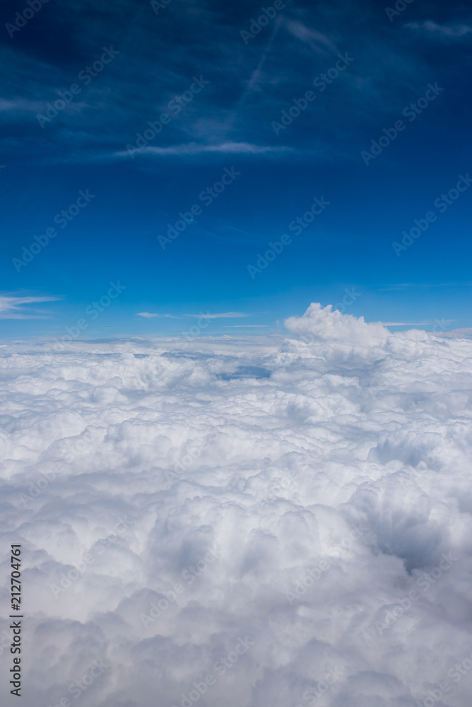 blue sky full of clouds seen from the plane in summer