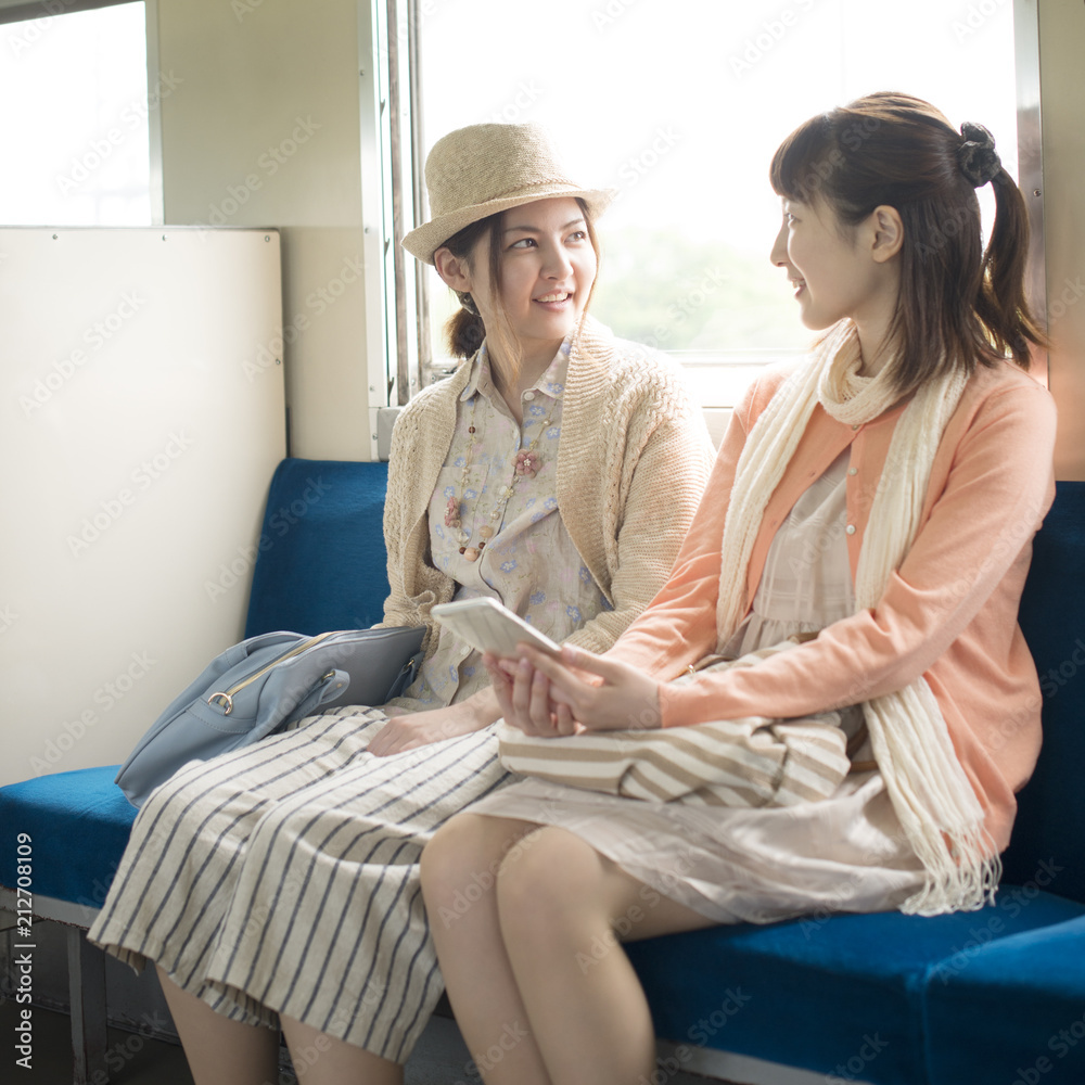 電車の中で談笑をする2人の女性 Stock Photo Adobe Stock