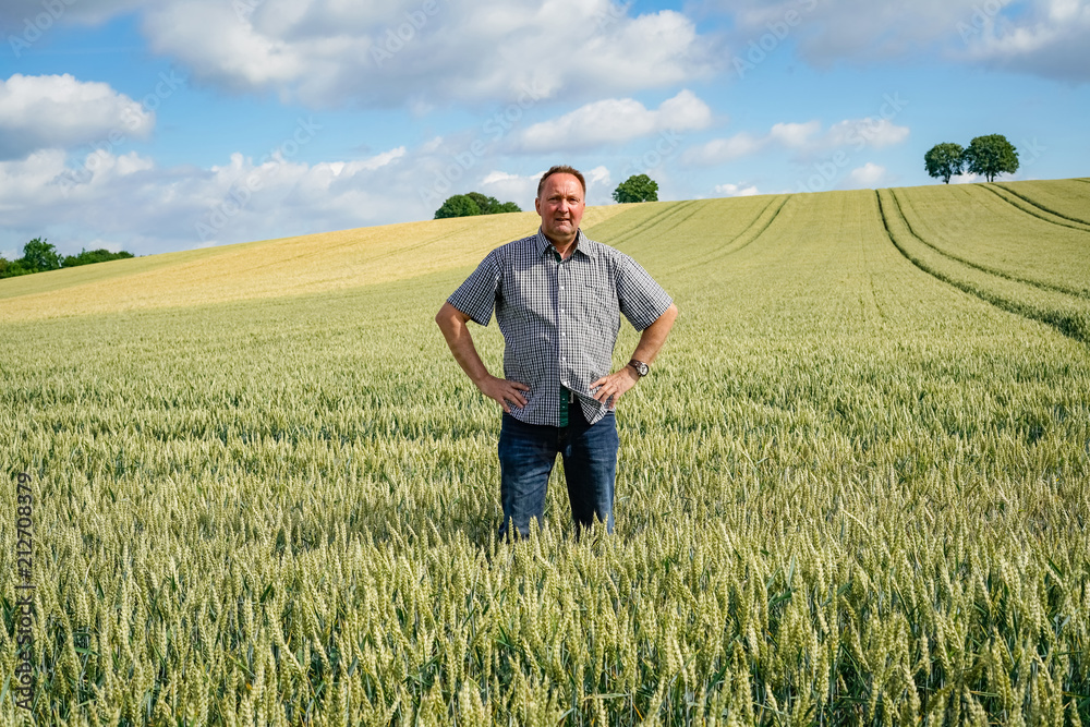 Ackerbau - Landwirt blickt stolz über seine Getreidefelder Ackerbau - Landwirt blickt stolz über seine Getreidefelder