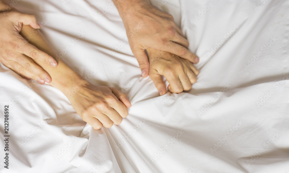 couple hands pulling white sheets in ecstasy, orgasm. Concept of passion. Orgasm. Erotic moments. Intimate concept. Sex couple. Bedroom couple hands pulling white sheets in ecstasy, orgasm. Concept of passion. Orgasm. Erotic moments. Intimate concept. Sex couple. Bedroom