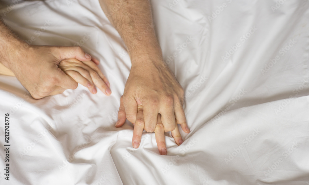 couple hands pulling white sheets in ecstasy, orgasm. Concept of passion. Orgasm. Erotic moments. Intimate concept. Sex couple. Bedroom couple hands pulling white sheets in ecstasy, orgasm. Concept of passion. Orgasm. Erotic moments. Intimate concept. Sex couple. Bedroom