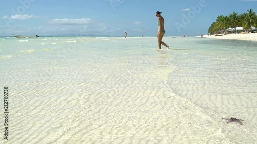 A woman walks into the sea and sits down photo