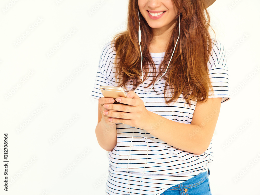 beautiful girl in casual hipster summer clothes with no makeup in brown hat listening music in smartphone with headphones isolated on white. Dancing beautiful girl in casual hipster summer clothes with no makeup in brown hat listening music in smartphone with headphones isolated on white. Dancing
