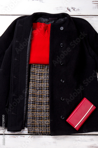 Collection of winter women apparel. Folded sweater and trousers in black coat.