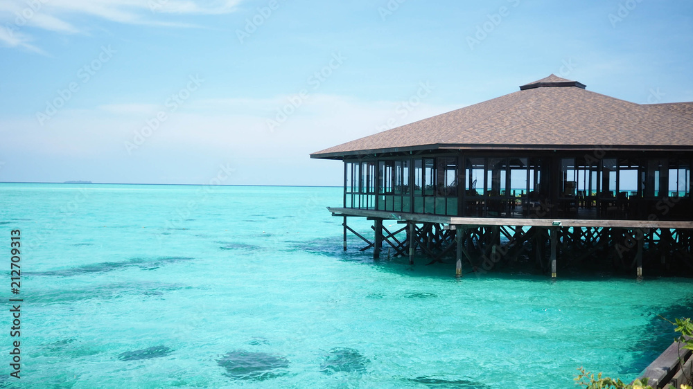 resort view of clear aqua water and bungalow