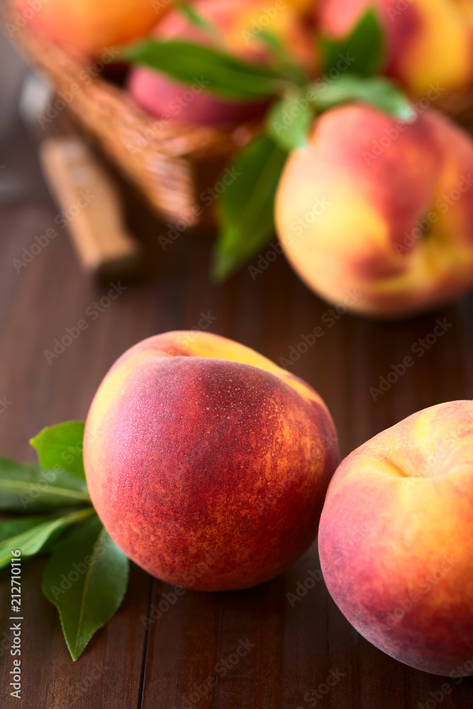 Fresh ripe peaches, photographed on dark wood with natural light (Selective Focus, Focus on the front of the front left peach) Fresh ripe peaches, photographed on dark wood with natural light (Selective Focus, Focus on the front of the front left peach)