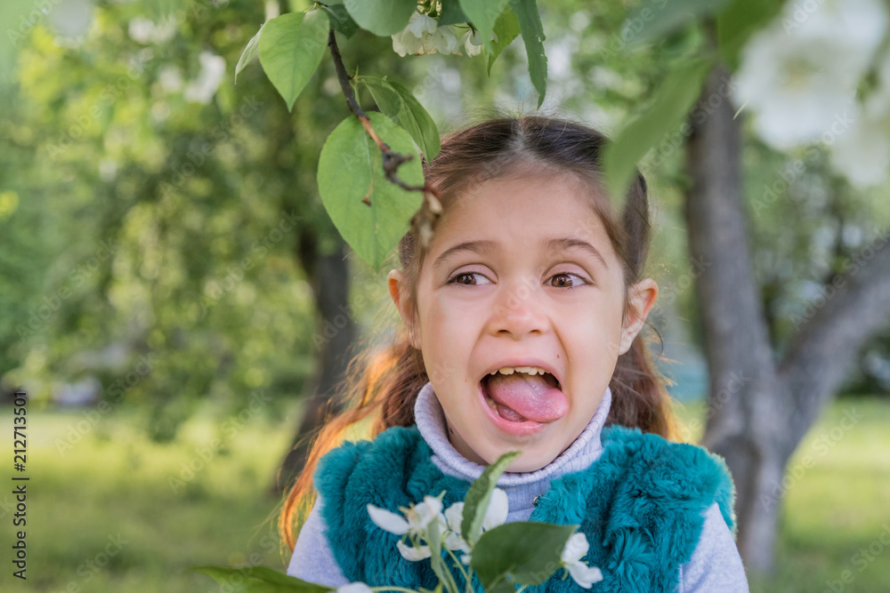 Little girl in green garden in sunny day Little girl in green garden in sunny day