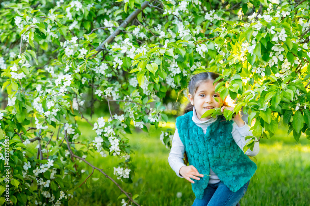 Little girl in green garden in sunny day Little girl in green garden in sunny day