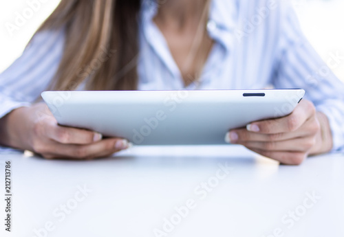 close up of young business woman using a tablet computer sitting on terrace.