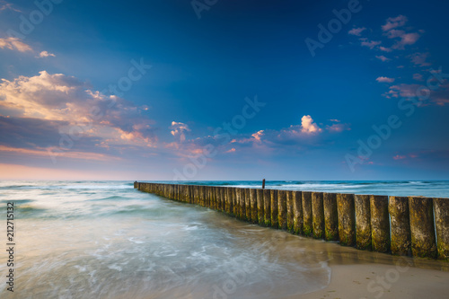 Fototapeta Naklejka Na Ścianę i Meble -  Sunset on the beach with breakwater, long time exposure