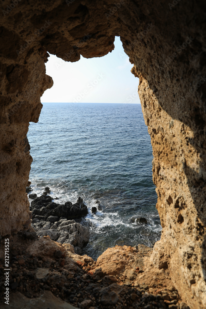 Beautiful seascape view through loophole of Monemvasia medieval castle overlooking the Aegean sea. Monemvasia, Peloponnese, Greece, June 2018.
