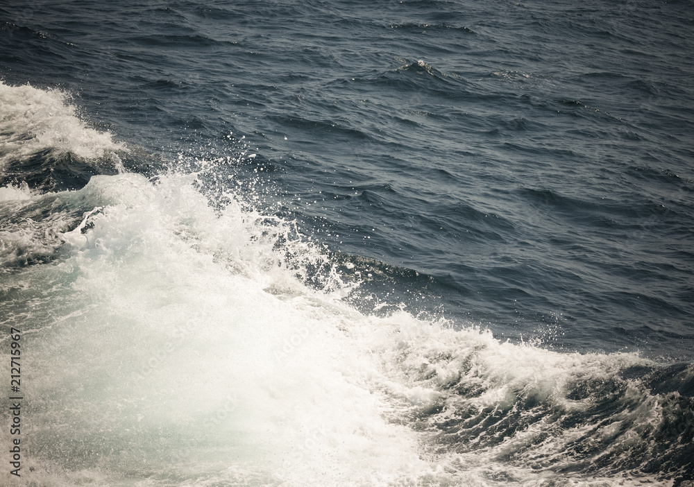 White crest of a sea wave. Selective focus. Shallow depth of field. Toned
