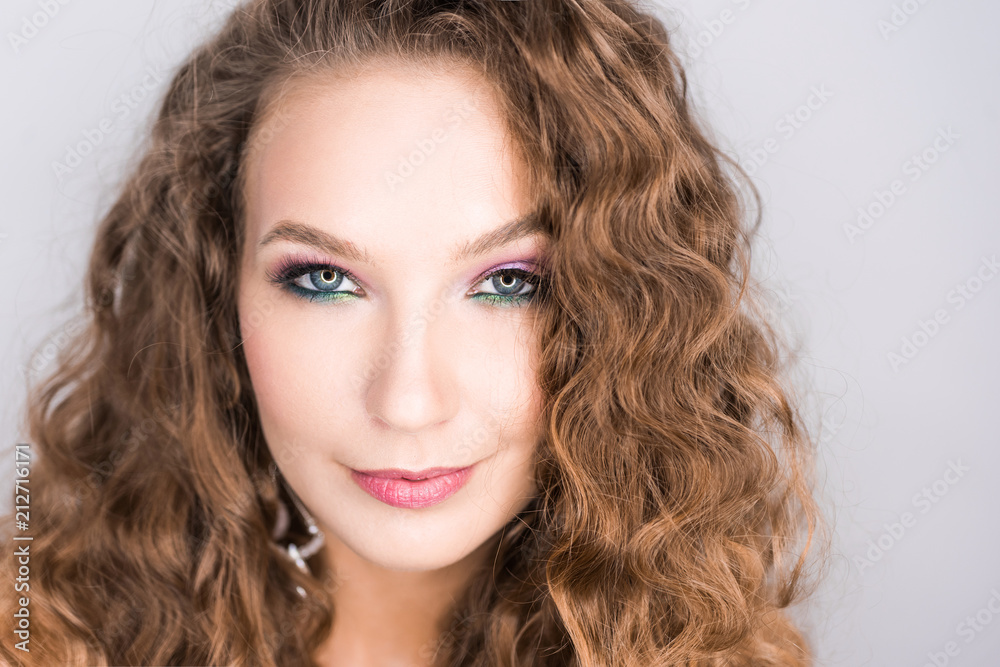 portrait beautiful young blonde curly girl posing in the studio with professional make-up and open tooth smile portrait beautiful young blonde curly girl posing in the studio with professional make-up and open tooth smile