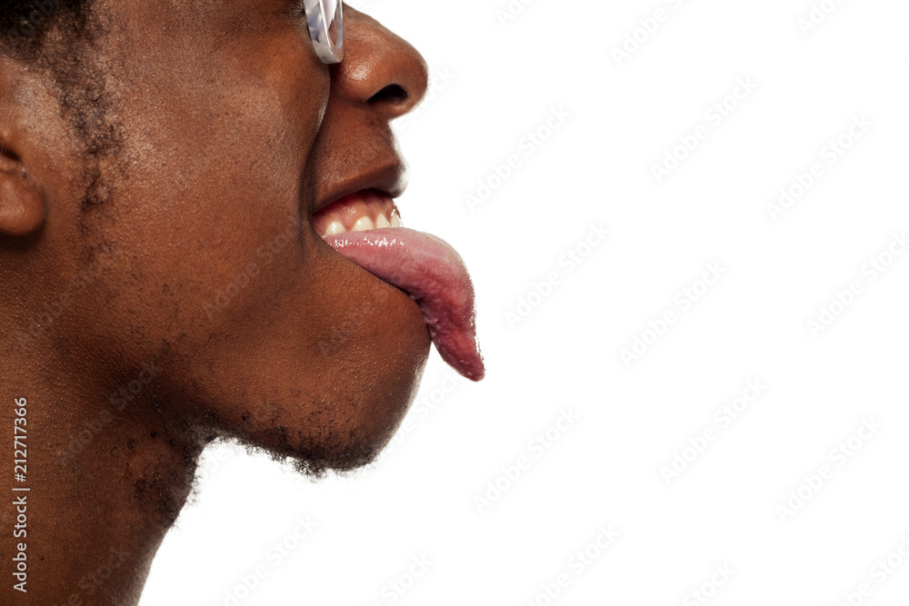Naklejka premium Profile tongue out closeup of young black african american guy on white background