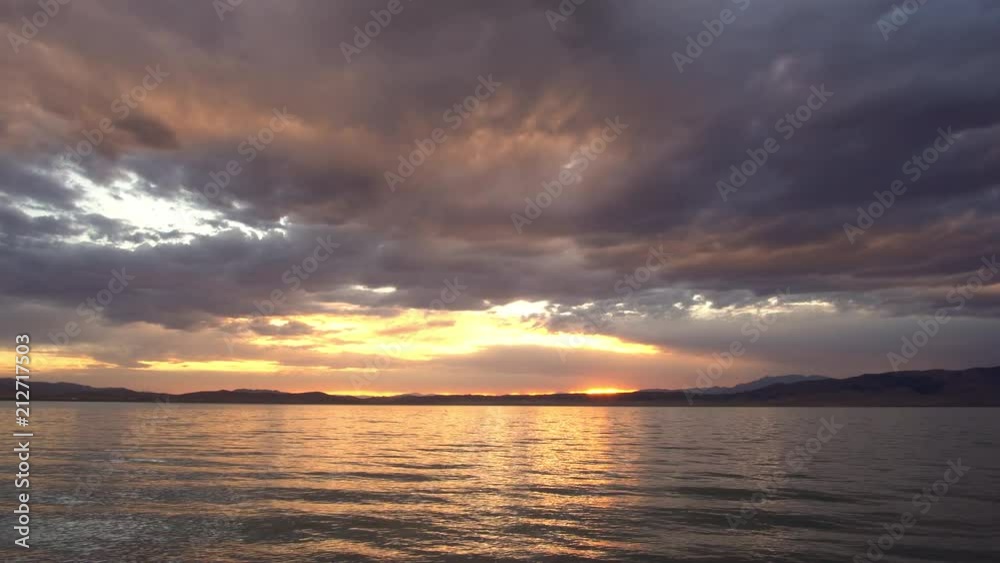 Colorful sunset reflecting in Utah Lake as the sun peaks through as it sets. Colorful sunset reflecting in Utah Lake as the sun peaks through as it sets.