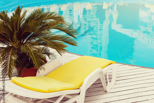 Obraz na plátně swimming pool with yellows sun lounger