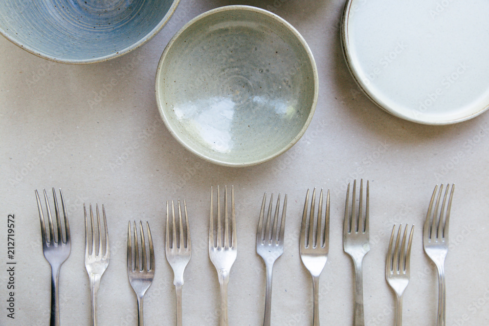 Bowls and forks are laid out for a table setting to be made. Bowls and forks are laid out for a table setting to be made.