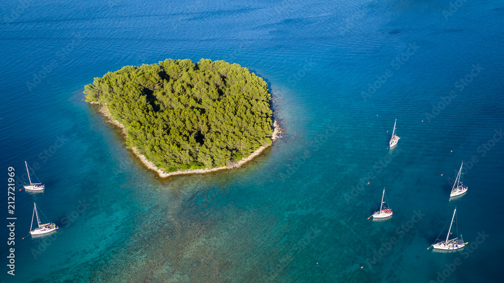 Naklejka premium Aerial view of sailing boats anchoring next to small island
