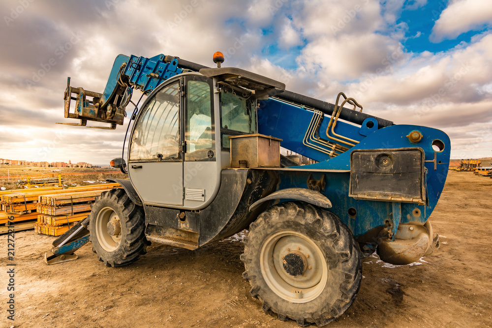 Forklift on a construction site, preparing to raise construction parts Forklift on a construction site, preparing to raise construction parts