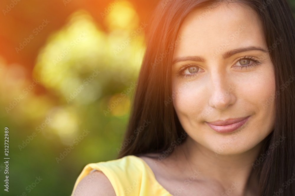 Naklejka premium Beautiful woman on field under sunset light