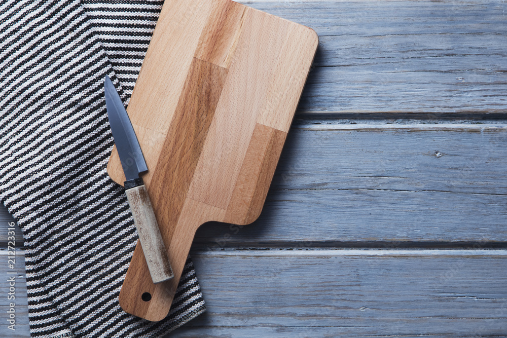 Wooden chopping board and cloth on a rustic wood plank table Wooden chopping board and cloth on a rustic wood plank table