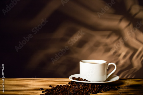 Coffee in a cup on wooden table opposite a defocused background. Collage. Selective focus