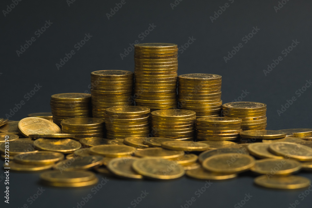 Savings, increasing columns of coins, piles of coins arranged as a graph in dark room, business banking concept. Savings, increasing columns of coins, piles of coins arranged as a graph in dark room, business banking concept.