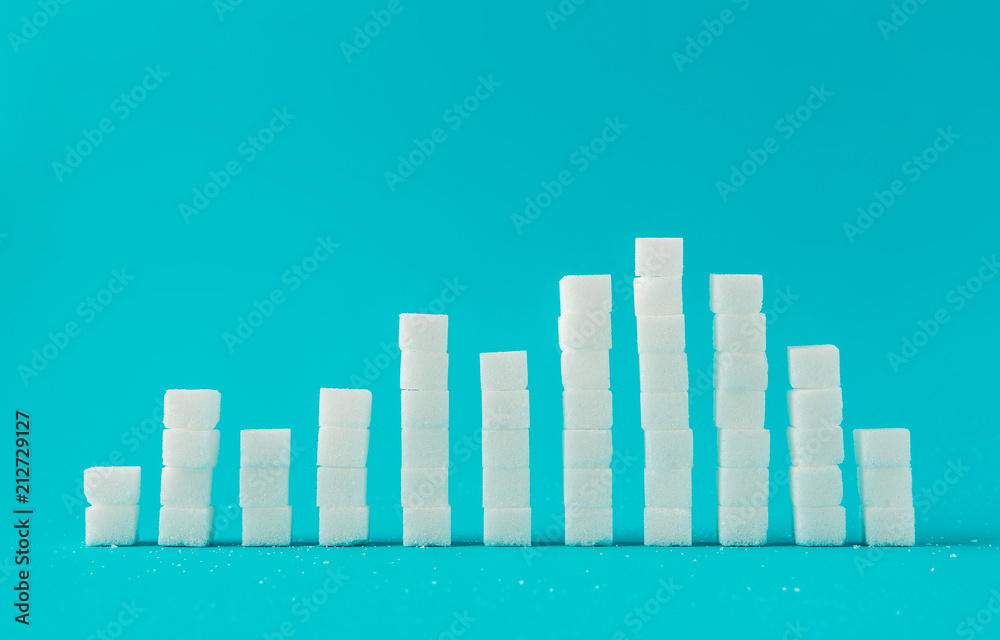 Fototapeta premium Financial chart made of sugar cubes with blue background. Sugar consumption growth rate world market concept.