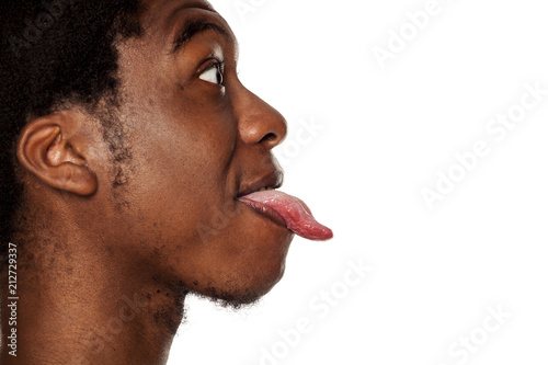 Profile tongue out closeup of young black african american guy on white background