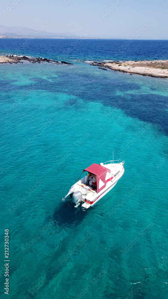 Aerial bird's eye view photo taken by drone of red cruise boat docked in caribbean tropical turquoise - sapphire waters