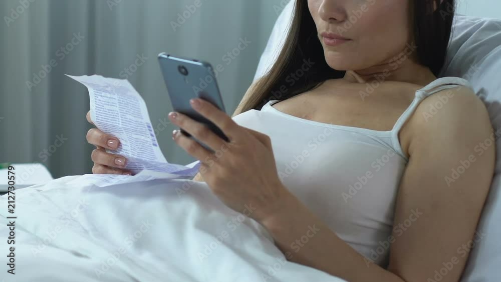Sick lady holding medication instruction and ordering pills online by smartphone