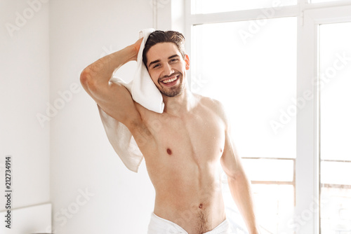 Naked man standing indoors at bathroom