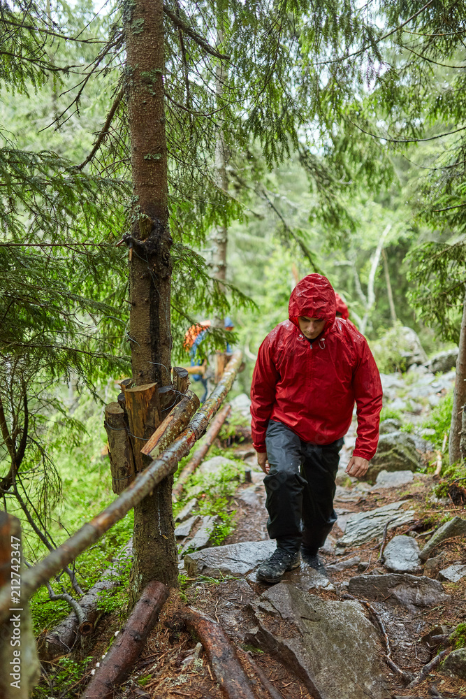 Man with raincoat hiking on a trail Man with raincoat hiking on a trail
