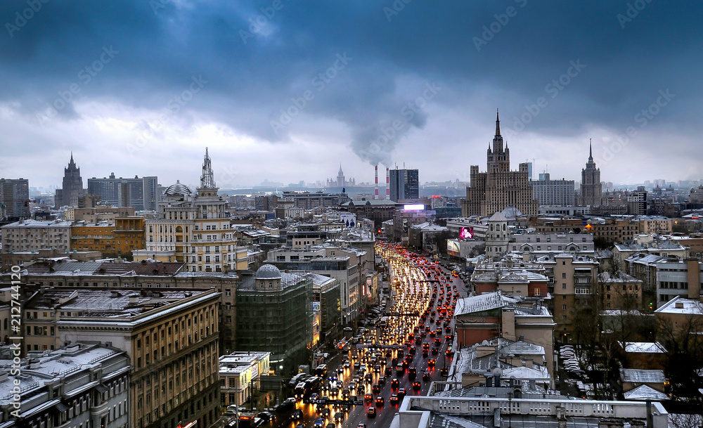 panorama of the city of Moscow with a cloudy sky and loaded highway. A traffic jam on the road. Stalinist architectural buildings