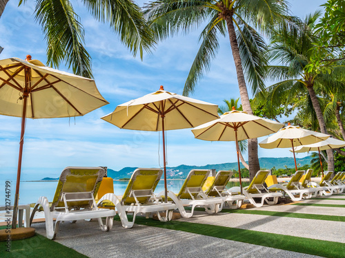 Umbrella and chair around luxury outdoor swimming pool