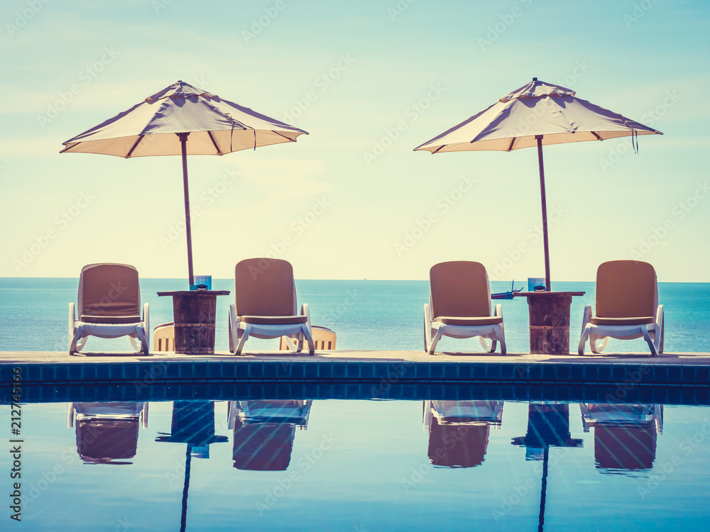 Fototapeta premium Umbrella and chair around luxury outdoor swimming pool