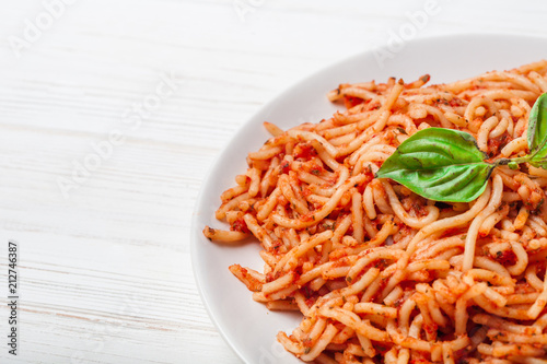 Italian spaghetti with a bolognese tomato meat sauce and basil in a plate. Copy space. Italian food concept.