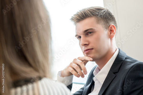 Young handsome caucasian businessman thinking with hand on chin