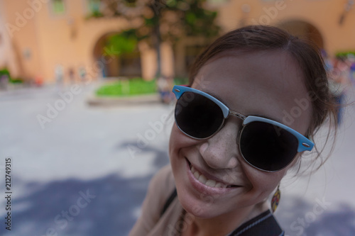 Young woman tourist in the sunglasses and in excellent spirits.