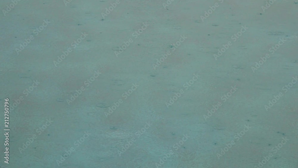 Drops of rain fall on the surface of the water in the pool. Slow motion. Creating a pattern of circular waves on water surface.
Drops of rain fall on the surface of the water in the pool. Slow motion. Creating a pattern of circular waves on water surface.